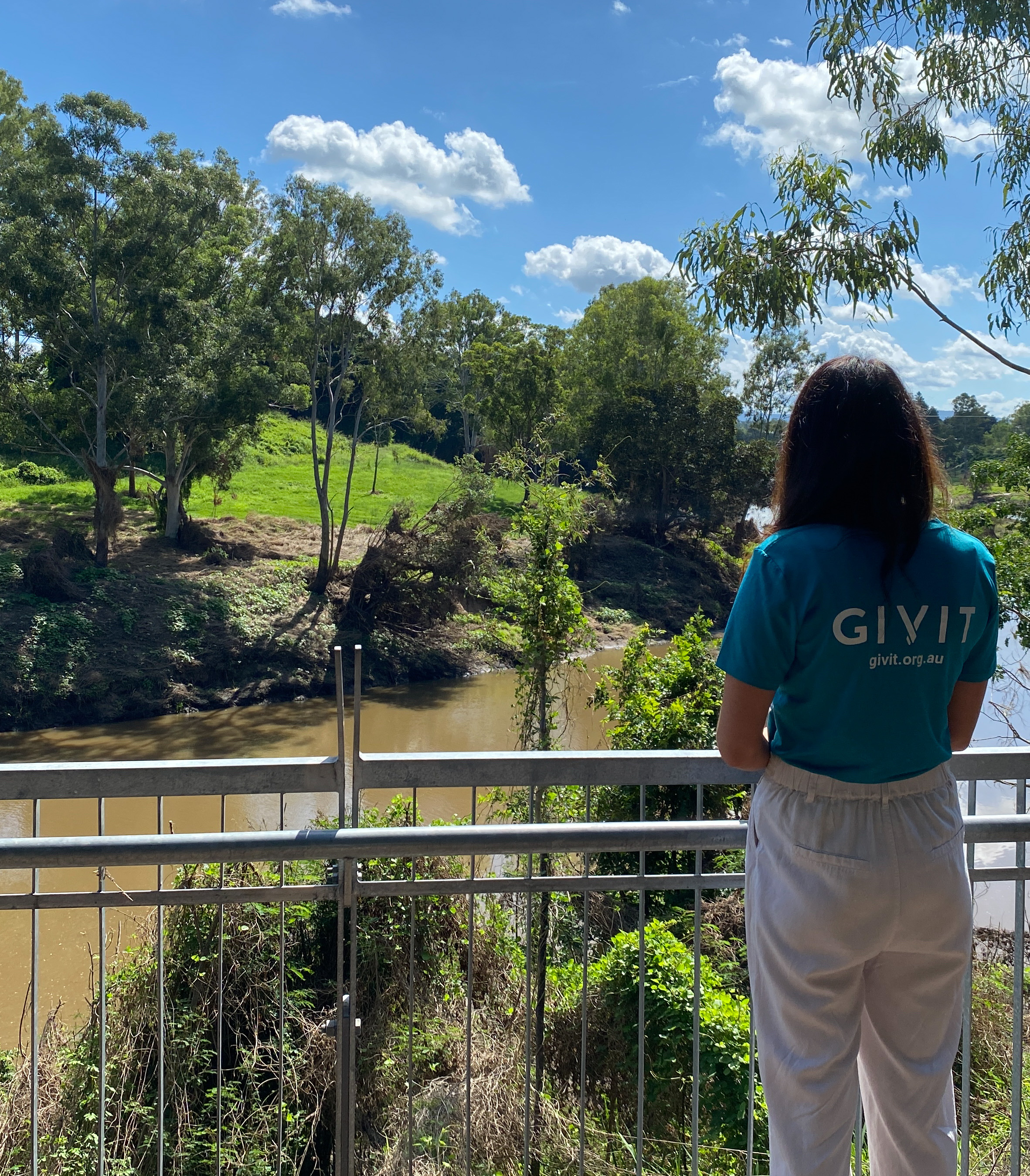 GIVIT staff member looking at flood waters