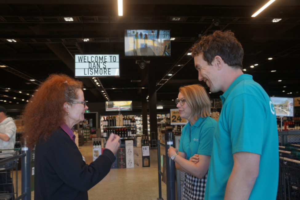 GIVIT staff members Jay and Denim chatting a Dan Murphy's staff member at the Lismore store after its reopening following flooding in 2022.