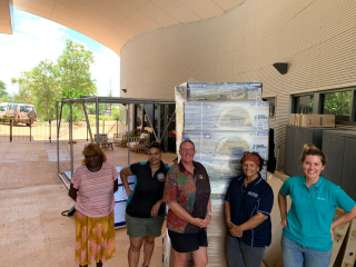 Engagement Officer Sarah with four female recovery workers standing in front of boxes of swags.